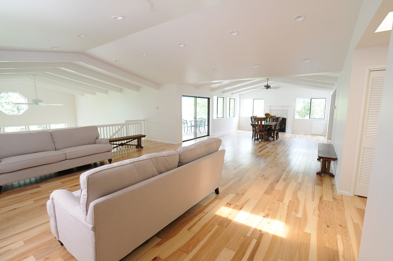 custom design open living space with wood flooring and vaulted ceiling