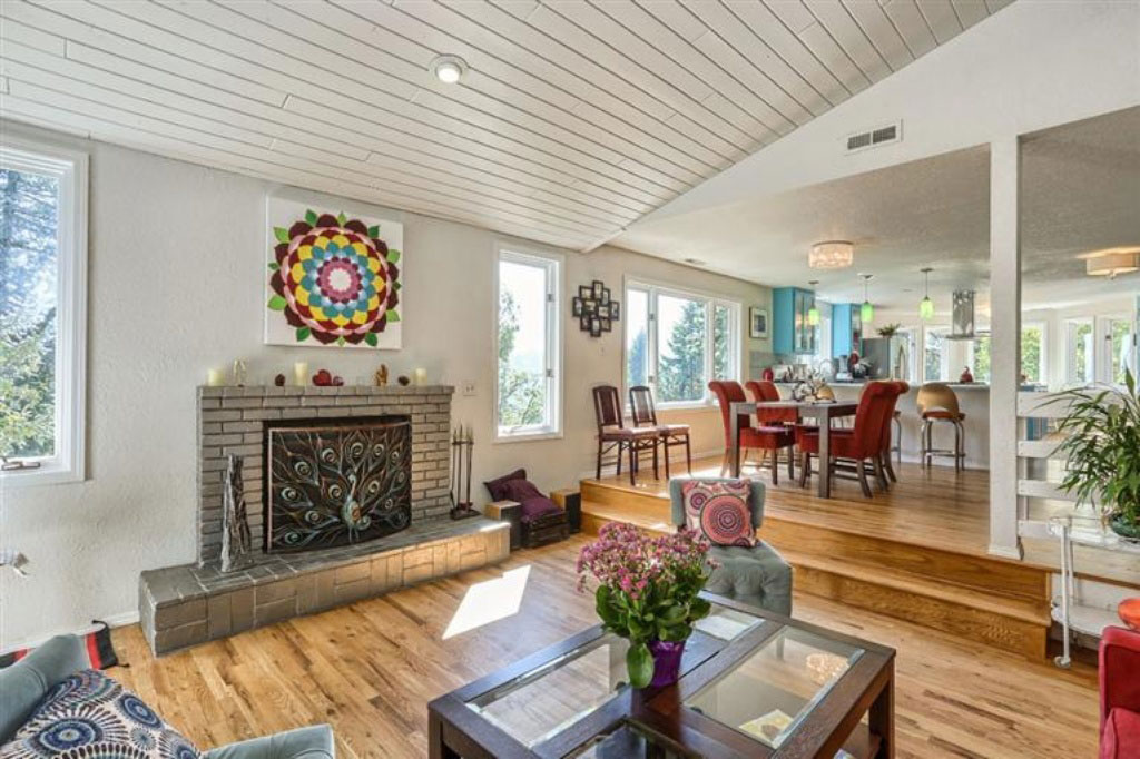 home remodeled living room with fireplace, wood flooring, vaulted barrel ceiling